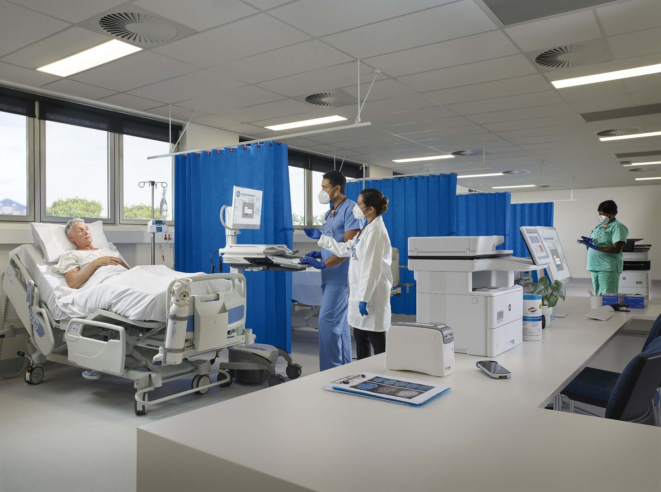 Spoedeisende hulp in het ziekenhuis met een patiënt in bed, twee artsen en een HP LaserJet-printer op de voorgrond